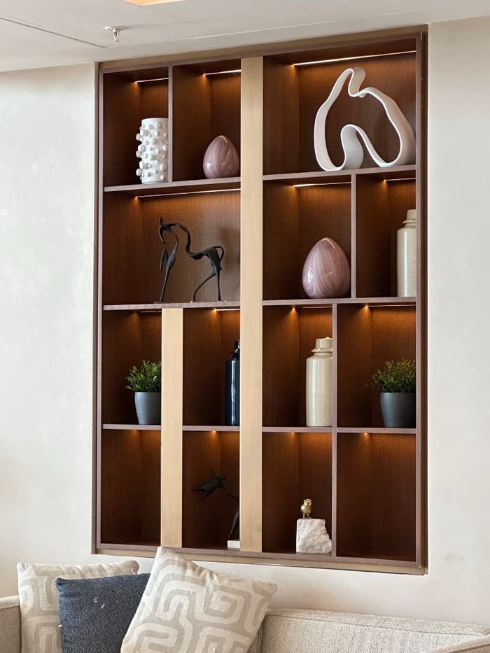 Stylish wooden wall shelf with decor items in a modern living room.