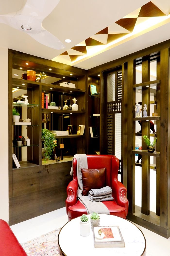 Elegant indoor setting featuring a vibrant red armchair and contemporary bookshelf design.